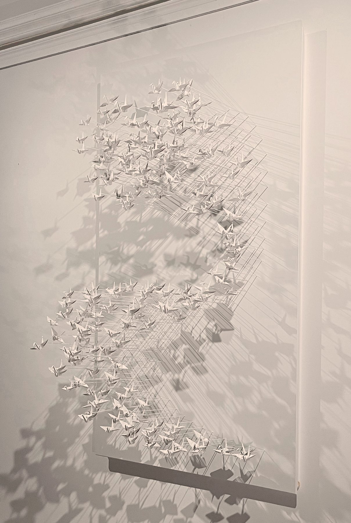 Murmuration 28, nuée de grues en papier blanc sur panneau.