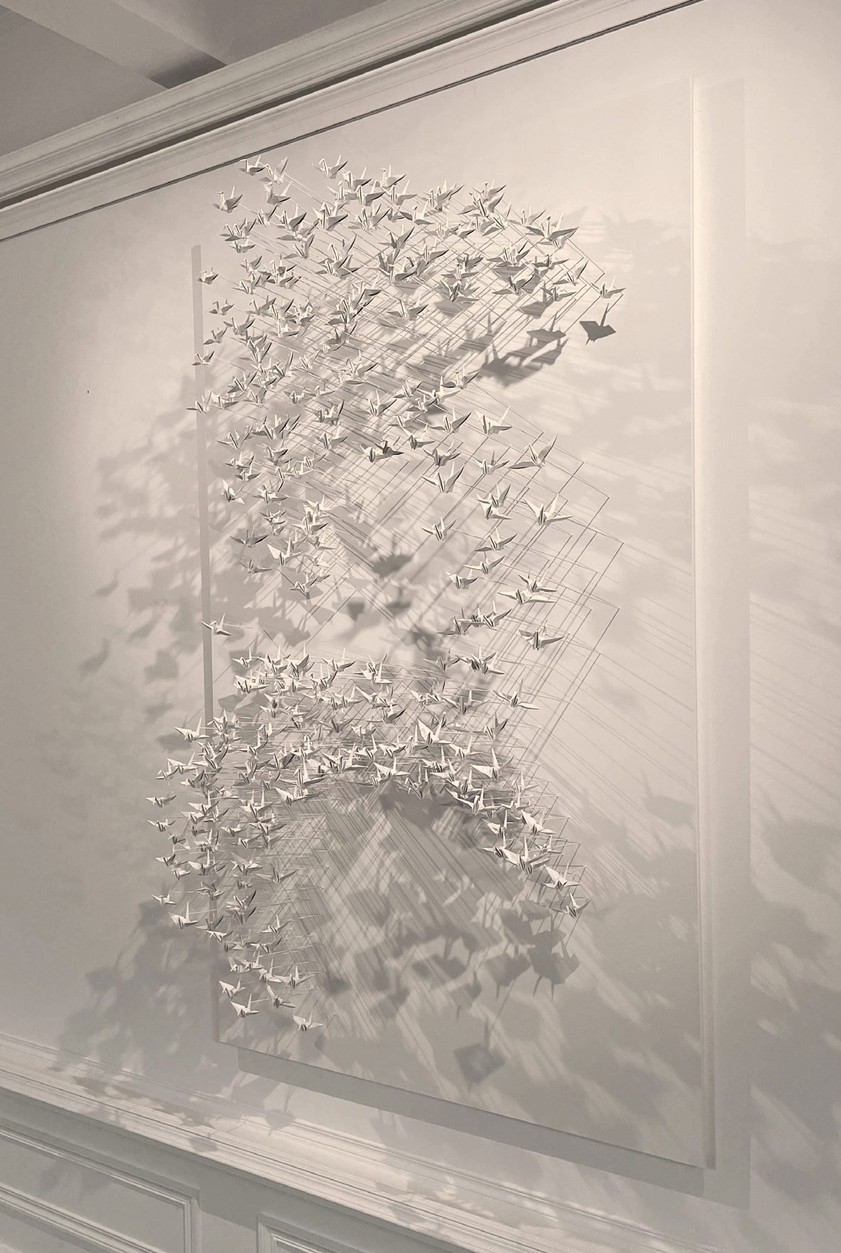 Murmuration 29, nuée de grues en papier blanc sur panneau.