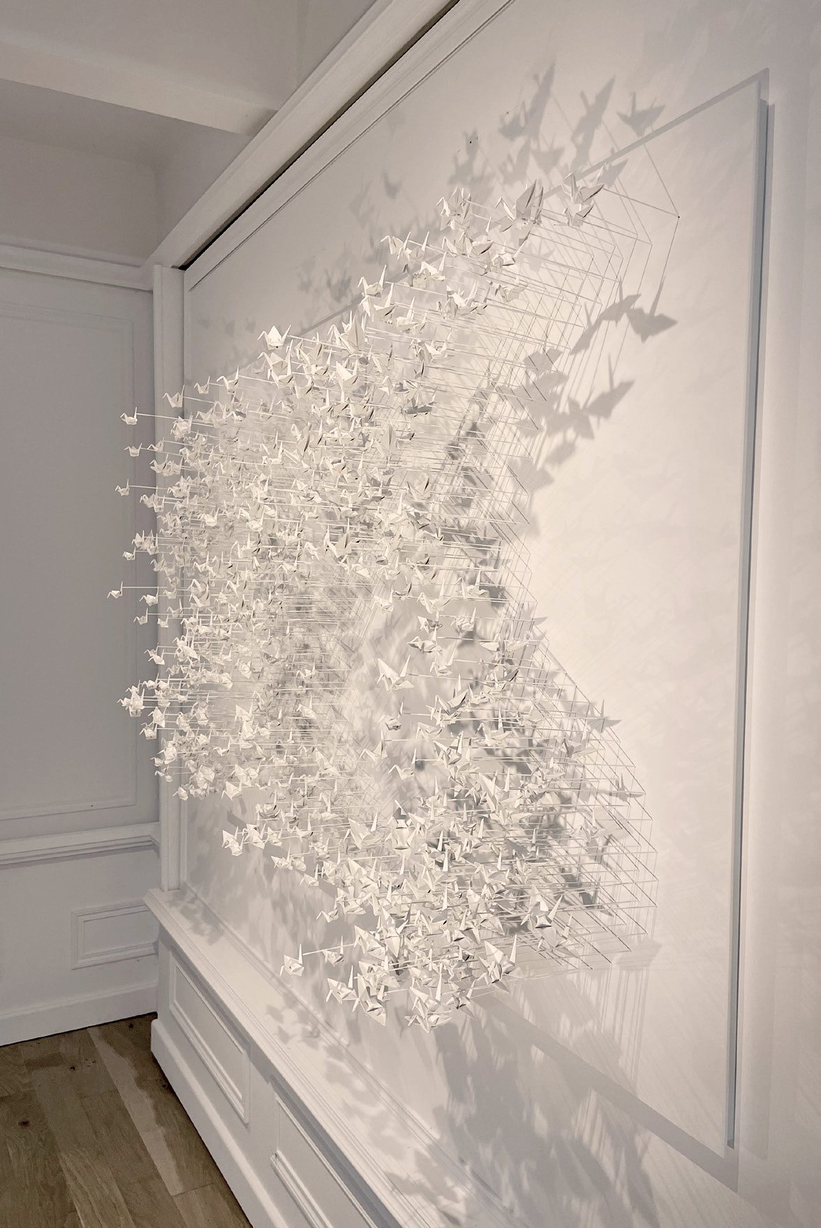 Murmuration 32, nuée de grues en papier blanc sur panneau.