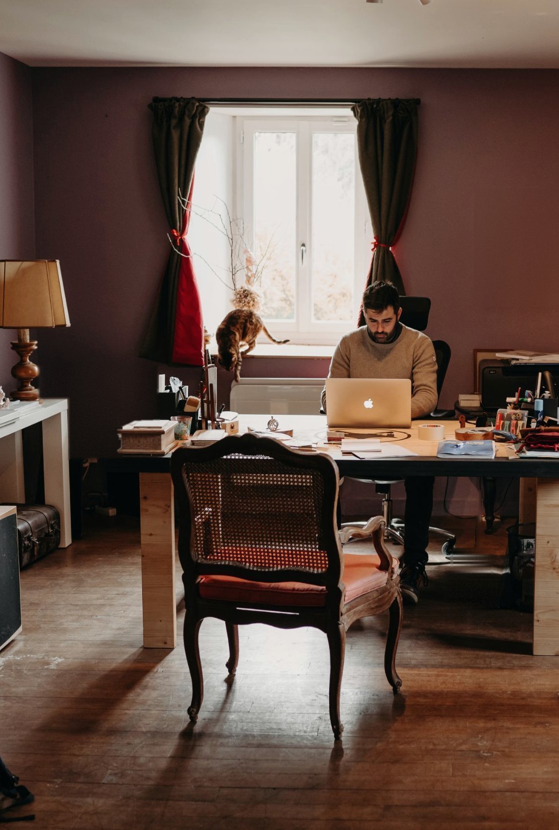 Benjamin Gaumard travaille à son bureau, au studio, devant une fenêtre.
